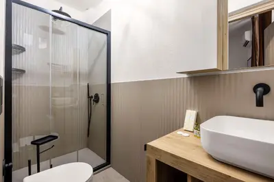 a bathroom with a sink and a glass shower at G e B Central Apartment in Palermo