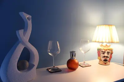 a table with two wine glasses and a lamp at FALSTAFF Rooms & Suites in Palermo