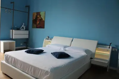 a blue room with a bed with two pillows on it at FALSTAFF Rooms & Suites in Palermo
