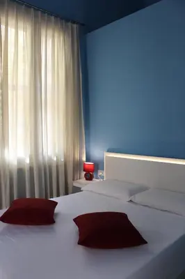 a bedroom with two white beds with red pillows at FALSTAFF Rooms & Suites in Palermo