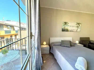 a bedroom with a bed and a balcony at B&B Blue in Terrasini