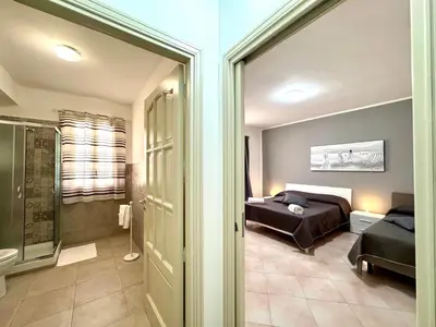 a bedroom with a bed and a bathroom at B&B Blue in Terrasini