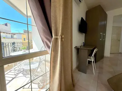 a room with a balcony with a desk and a window at B&B Blue in Terrasini