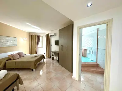 a hotel room with two beds and a bathroom at B&B Blue in Terrasini