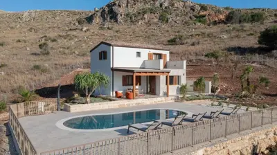 a villa with a swimming pool in front of a house at Villa Eos con piscina privata in Scopello