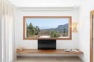 a living room with a tv and a window at Villa Eos con piscina privata in Scopello