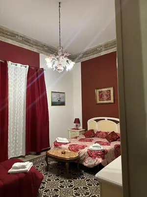 a bedroom with two beds and a table in it at B&B Salinas in Palermo