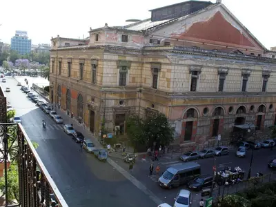 a large building with cars parked in front of a street at B&B Salinas in Palermo