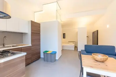 a kitchen and living room with a table and a blue couch at Loft Piazza Marina By DomuSicily in Palermo