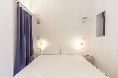 a bedroom with a large bed with blue curtains at Loft Piazza Marina By DomuSicily in Palermo