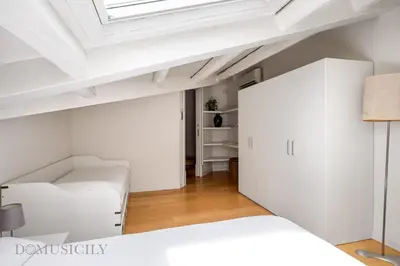 a bedroom with a white bed and a skylight at Elvi Penthouse by DomuSicily in Palermo
