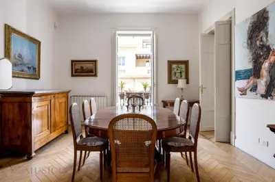 a dining room with a wooden table and chairs at Elvi Penthouse by DomuSicily in Palermo