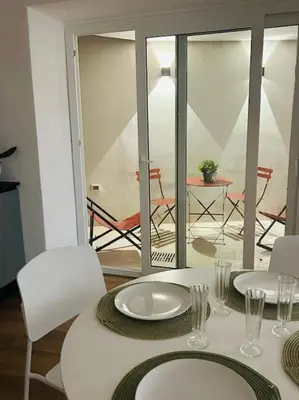 a white table with white plates and chairs and a balcony at La Casa Di Mitì in Palermo