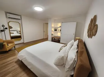 a bedroom with a large white bed and a mirror at La Casa Di Mitì in Palermo