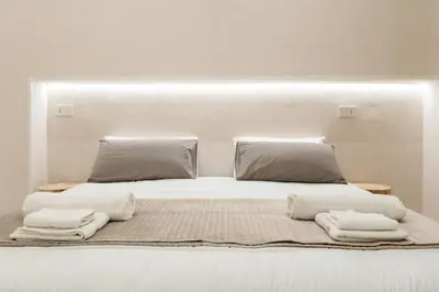 a white bed with towels on top of it at Ambrosia Suite in Palermo
