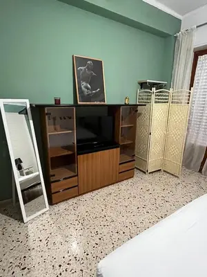 a room with a bed and a tv and a mirror at Casina Della Strega in Palermo