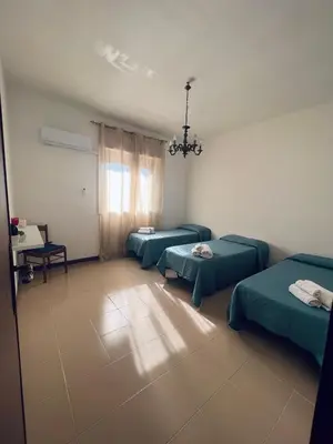 a hospital room with three beds and a chandelier at Sun House in Palermo