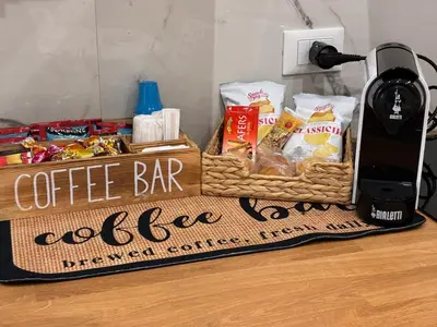 a coffee bar sign on a table with some snacks at Ludo Holiday House - Charming con patio a due passi dalla cattedrale in Palermo
