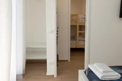 a bedroom with white walls and a closet at Ludo Holiday House - Charming con patio a due passi dalla cattedrale in Palermo