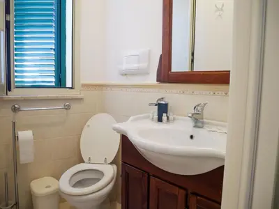 a bathroom with a sink and a toilet and a mirror at Casa del pescatore - fronte mare di Mondello - By Rentalbeb italy- in Palermo