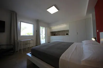 a bedroom with a large bed and a kitchen at IRIS HOME Private Pool in Alcamo