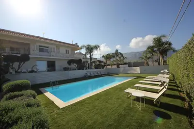 a swimming pool with lounge chairs and a house at IRIS HOME Private Pool in Alcamo