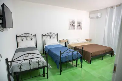 two beds in a room with green flooring at Case D'irene in Capaci