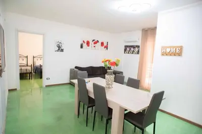 a dining room and living room with a table and chairs at Case D'irene in Capaci