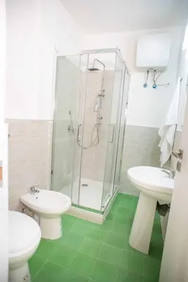 a bathroom with a shower and two sinks and a toilet at Case D'irene in Capaci
