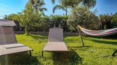 three chairs and a hammock in a yard at Villa Lumia in Campofelice di Roccella
