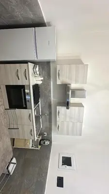 a kitchen with white cabinets and a tv on the wall at La casetta del centro in Palermo