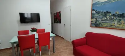 a living room with a red couch and a table at Casa Renda in Balestrate