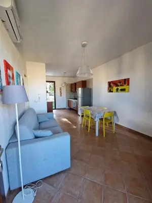 a living room with a blue couch and a table at Triskelia in San Vito lo Capo