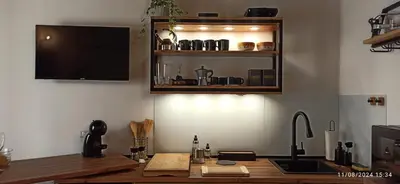 a kitchen with a counter with a sink and a tv at Jujube hortus apartment 4 in Palermo