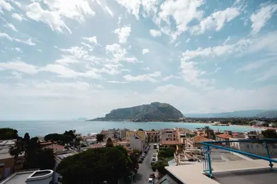 a view of a city and the ocean with a mountain at Mondello Glam Hotel & Terrace in Mondello