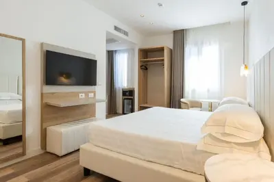 a hotel room with a bed and a tv at Mondello Glam Hotel & Terrace in Mondello
