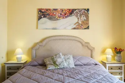 a bedroom with a bed with two night stands and a painting at La Terrazza di Massimo in Palermo