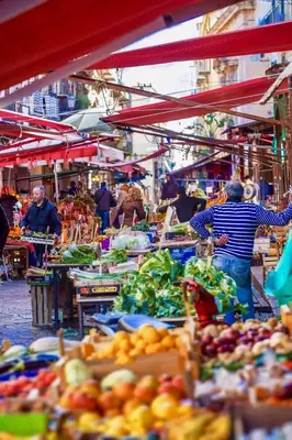 a man standing in a market with fruits and vegetables at La Terrazza di Massimo in Palermo