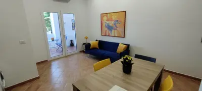a living room with a table and a blue couch at Casa Renda in Balestrate