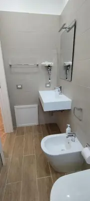 a bathroom with a sink and a toilet and a mirror at Casa Renda in Balestrate