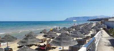 a row of umbrellas on a beach with the ocean at Casa Renda in Balestrate