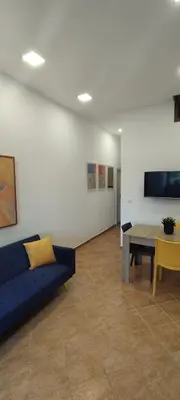 a living room with a blue couch and a table at Casa Renda in Balestrate