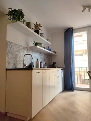 a kitchen with white cabinets and a large window at Liberty Blue House in Palermo