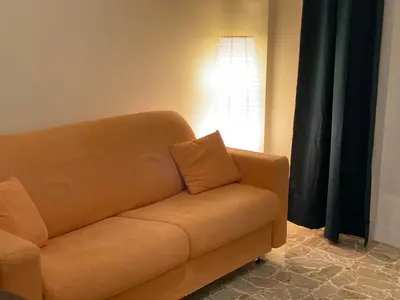 a brown couch sitting in a living room with a light at Casa Verdura in Palermo
