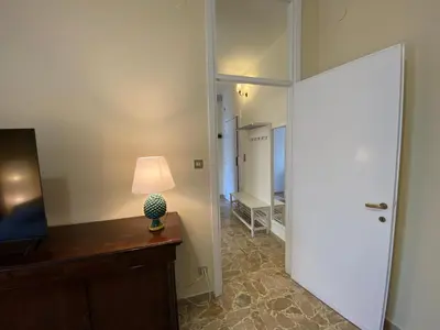 a hallway with a door and a lamp on a desk at Casa Verdura in Palermo
