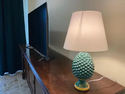 a lamp sitting on a table next to a television at Casa Verdura in Palermo