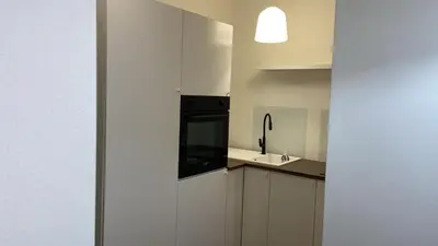 a white kitchen with a sink and a black appliance at Dedè Dream in Palermo