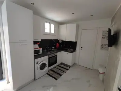 a small white kitchen with a washer and dryer at La casetta di Davide in Palermo