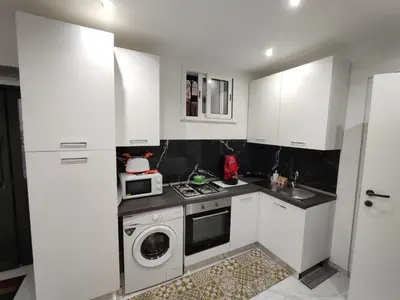 a kitchen with white cabinets and a washing machine at La casetta di Davide in Palermo