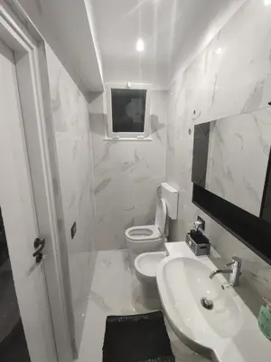 a white bathroom with a toilet and a sink at La casetta di Davide in Palermo